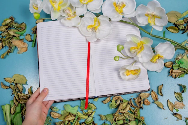 Bloc de notas y orquídea en el fondo