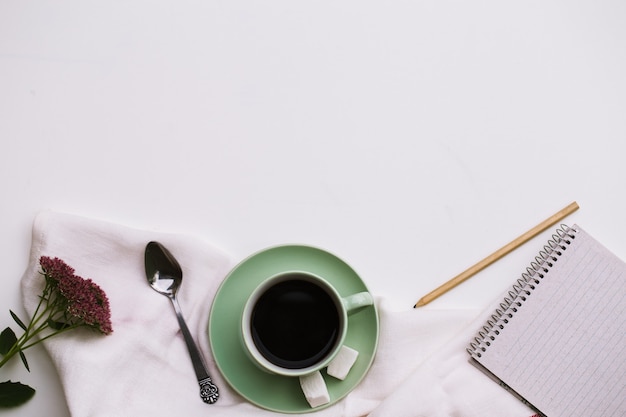 Bloc de notas y taza de café en blanco.