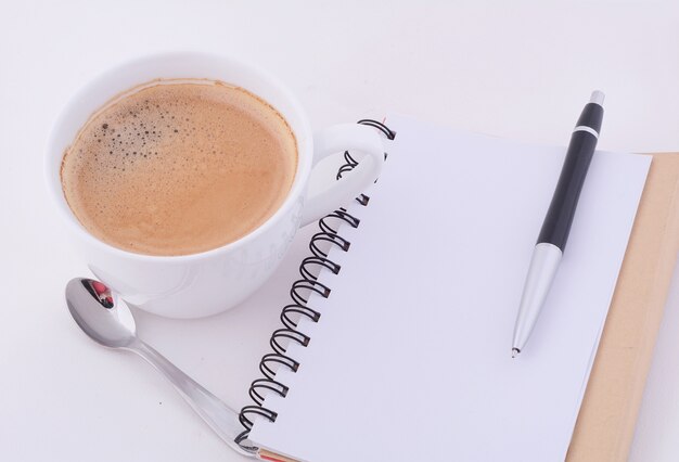 Foto bloc de notas con una taza de café.