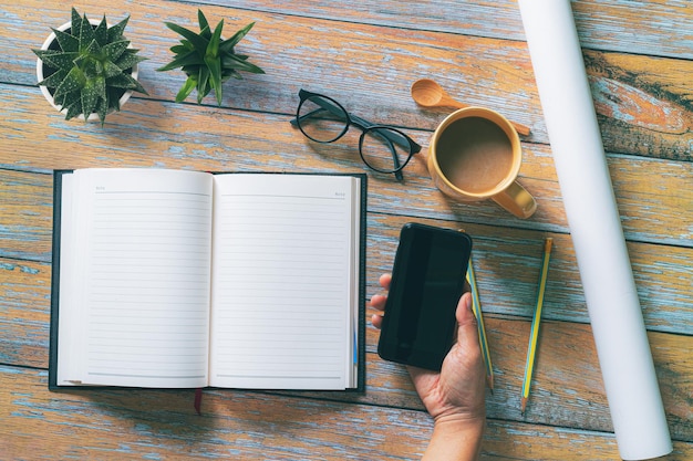 Bloc de notas y teléfono móvil en el escritorio y taza de café