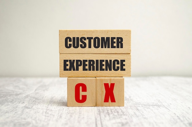 Bloco de madeira do cubo do conceito da experiência do cliente com o alfabeto CX importante do usuário centrado no produto e no serviço de negócios mundiais recentes