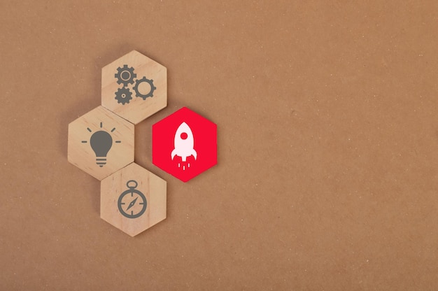 Bloco de madeira vermelho com ícone de lançamento de foguete Símbolos de desenvolvimento de inicialização de negócios de inovação de liderança