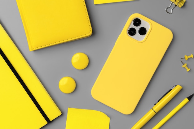 Bloco de notas amarelo com smartphone e caneta em fundo cinza