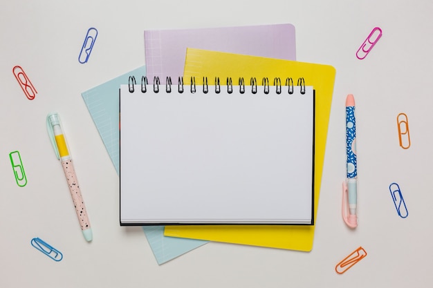 Bloco de notas, caderno e caneta na mesa. Zombe no escritório do espaço da cópia em fundo branco. De volta à escola