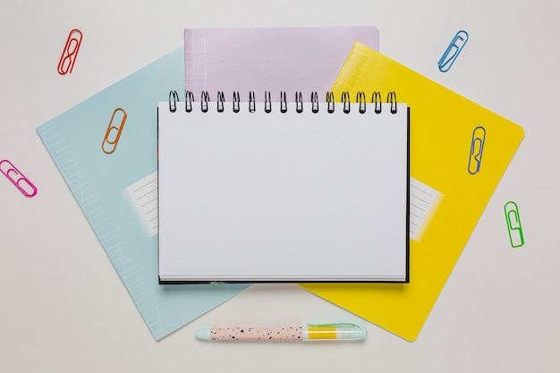 Bloco de notas, caderno e caneta na mesa. Zombe no escritório do espaço da cópia em fundo branco. De volta à escola