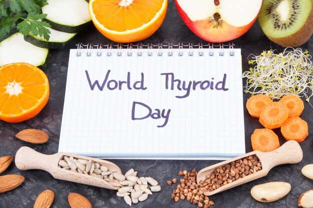 Foto bloco de notas com inscrição world thyroid day e os melhores ingredientes para uma tireoide saudável