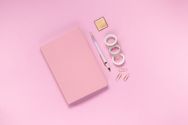Bloco de notas e cadernos em um fundo rosa