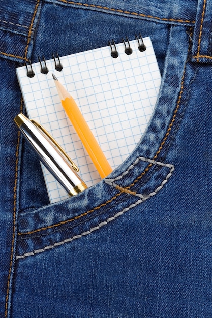 Bloco de notas e lápis com caneta no pacote de jeans