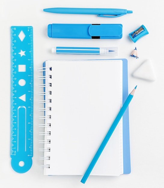 Bloco de notas em branco branco e turquesa material escolar no desktop branco, educação. Vista do topo.