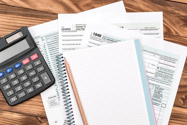 Bloco de notas em branco com calculadora de formulários de impostos e lápis na mesa Local de trabalho de negócios
