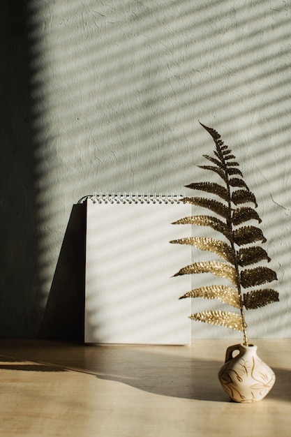 Bloco de notas em branco com sombras e luz dura