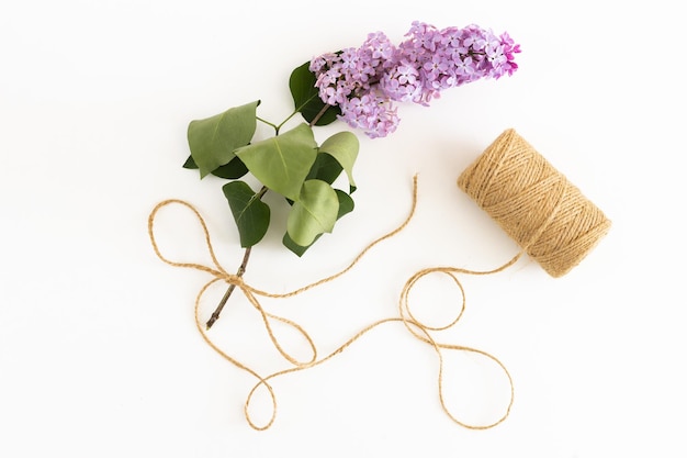 Bloco de notas limpo com flores lilás de primavera em fundo branco de madeira