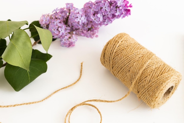 Bloco de notas limpo com flores lilás de primavera em fundo branco de madeira