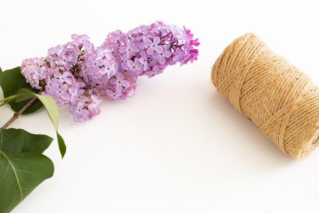 Bloco de notas limpo com flores lilás de primavera em fundo branco de madeira