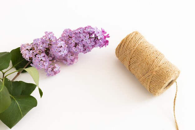 Bloco de notas limpo com flores lilás de primavera em fundo branco de madeira