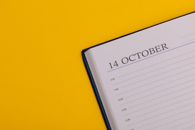 Bloco de notas ou diário com a data exata em um fundo amarelo Calendário para 14 de outubro, tempo de outono Espaço para texto