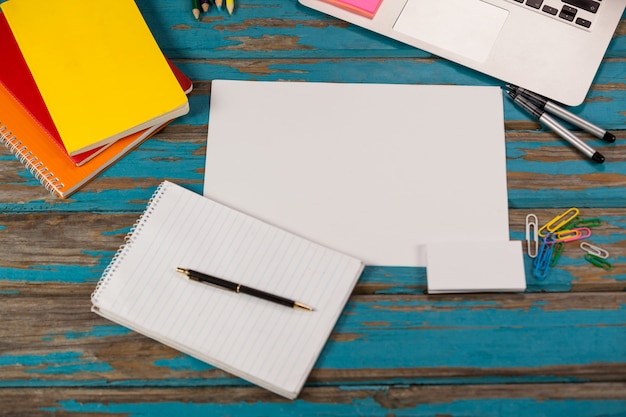 Foto bloco de notas, página em branco, agendas, canetas, lápis de cor, pinos de laptop e papel
