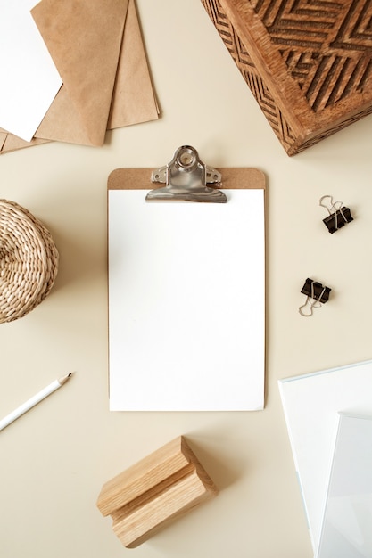 Bloco do tablet da área de transferência com folha de papel em branco. Espaço de trabalho da mesa do escritório doméstico do artista