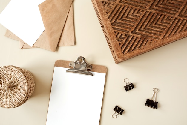 Bloco do tablet da área de transferência com folha de papel em branco. Espaço de trabalho da mesa do escritório em casa do artista. Camada plana, vista superior