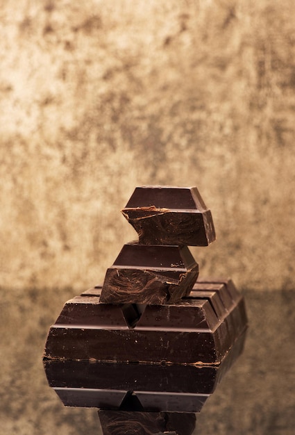 Blocos e pedaços de chocolate escuro em um fundo de pedra