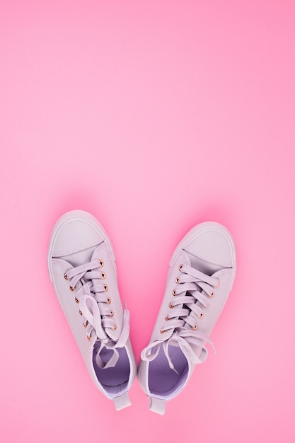 Blog de moda o concepto de revista. Zapatillas de deporte femeninas de color rosa sobre fondo rosa pastel.