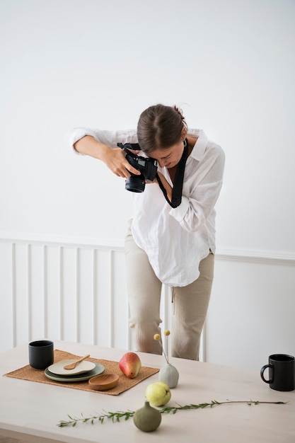 Blogger beim Fotografieren des Tellerdekors auf dem Esstisch