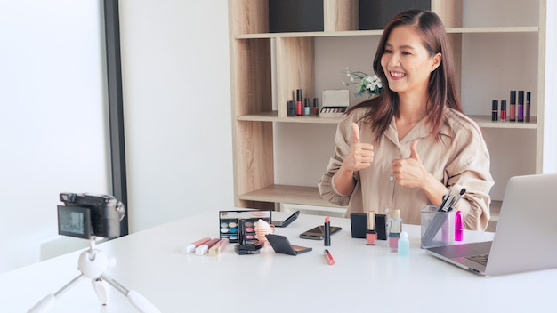 Blogger de belleza grabando video y presentando cosméticos en casa