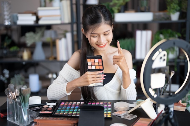 blogger de belleza joven artista de maquillaje asiática mujer profesional blogger vlogger está mostrando productos cosméticos con grabación de video influencer de belleza chica asiática video marketing en línea transmisión en vivo