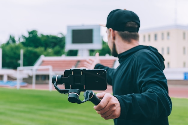 Foto blogger en el estadio graba video en un teléfono inteligente