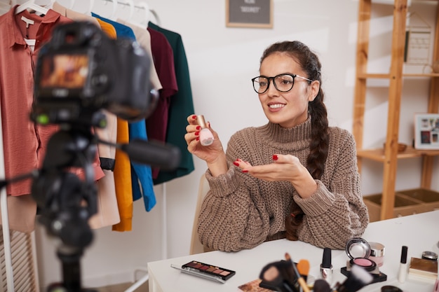 Blogger de estilo de vida filmando video sobre belleza y maquillaje