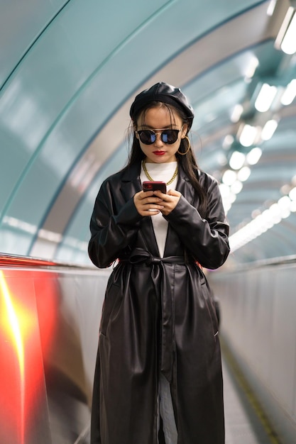 Blogger de estilo de vida joven chica coreana que publica en las redes sociales sube escaleras mecánicas desde la estación de metro