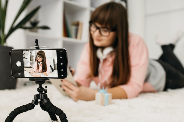 Foto blogger femenina streaming con smartphone y auriculares