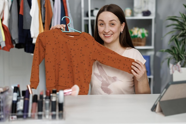 Foto blogger-frau zeigt lässige, farbenfrohe kleidung vor der kamera. stylistin-influencer-mädchen zeigt trendige kleidung