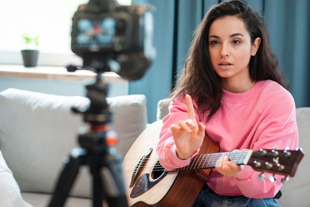 Blogger gravando vídeo com uma guitarra