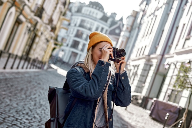 Blogger joven turista está caminando con la cámara en la ciudad vieja