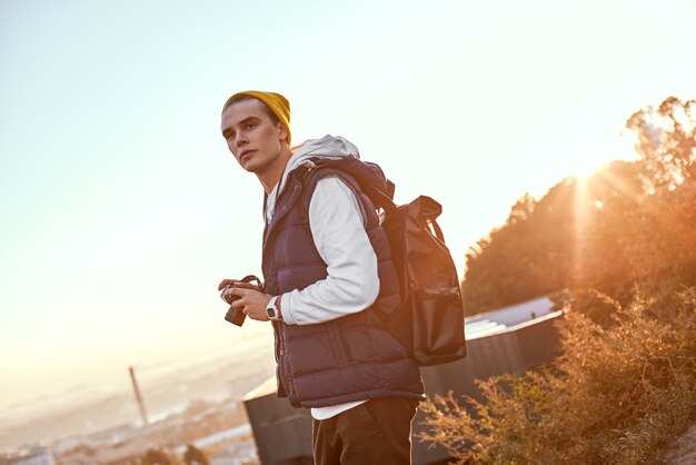 Blogger joven turista con sombrero hace una foto del amanecer