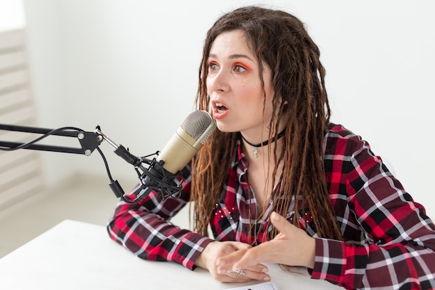 Foto blogger, locutor de rádio e conceito de pessoas - dj moderna expressiva com dreadlocks trabalhando no