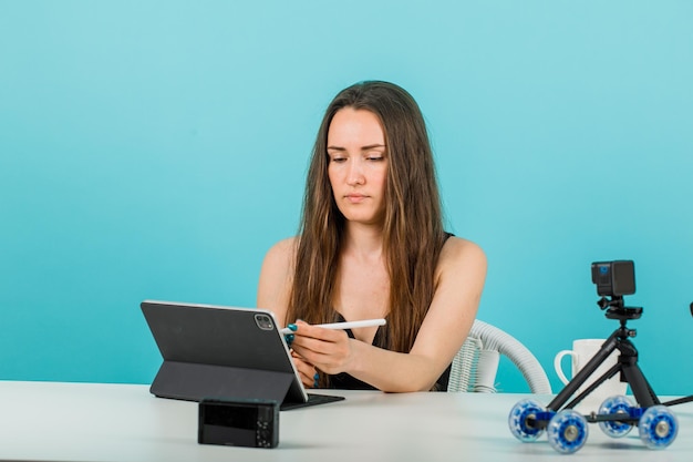 Blogger-Mädchen postet auf Tablet auf blauem Hintergrund