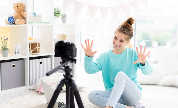 Blogger-Mädchen schießt Vlog vor der Kamera im hellen Raum