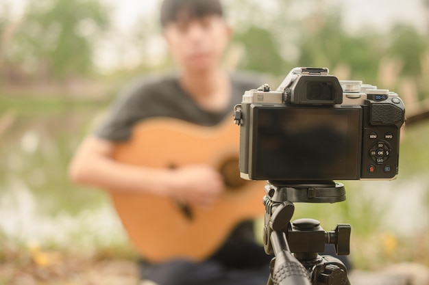 Blogger menino mostrando tocar guitarra streaming com seguidor de página de fã pela Internet on-line 5G