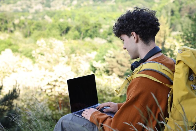 Blogger mit Rucksack unterwegs mit Laptop im Freien