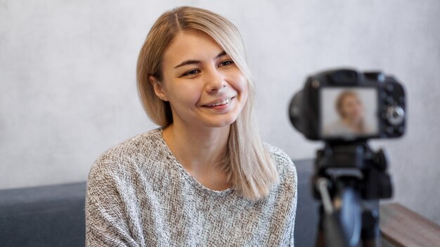 Blogger mujer alegre grabando video en casa