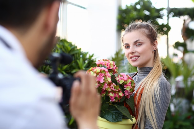 Foto blogger mujer grabando flor rosa en la cámara