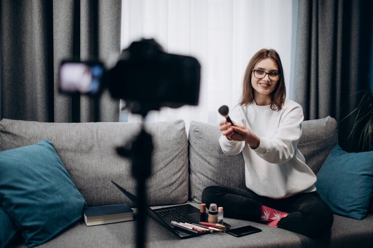 Blogger sonriente haciendo una revisión en línea sobre nuevos cosméticos