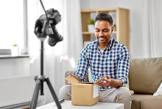 blogger de video masculino abriendo una caja de paquetes en casa