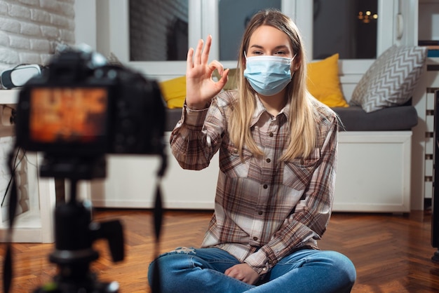 Bloggerin mit Gesichtsmaske, die Videos aufnimmt