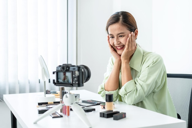 Foto bloggerin zeigt aktuelle make-up-tutorial-schönheitskosmetik-überprüfungsprodukte und sendet live-streaming-videos an soziale netzwerke, die online auf dem kamerabildschirm unterrichtet werden