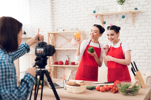 Los bloggers culinarios sostienen pimientos y cuchillos.