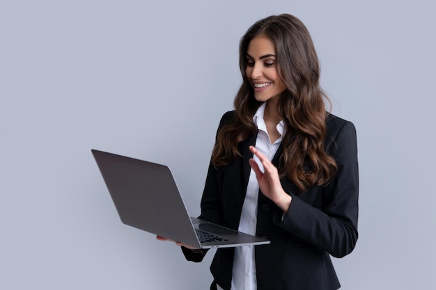 Blogging conversando mulher Retrato de jovem empresária usando computador portátil isolado em cinza