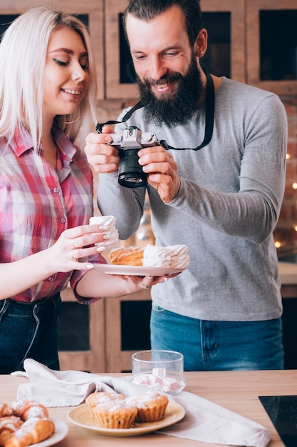 Blogs de comida. Estilo de vida de casal. Homem tirando fotos de bolos e doces caseiros frescos.